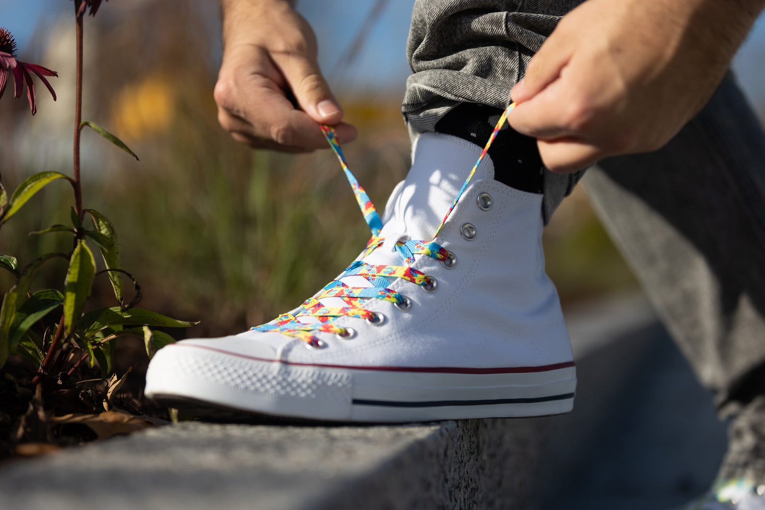 White shoe with colorful shoelaces being tied